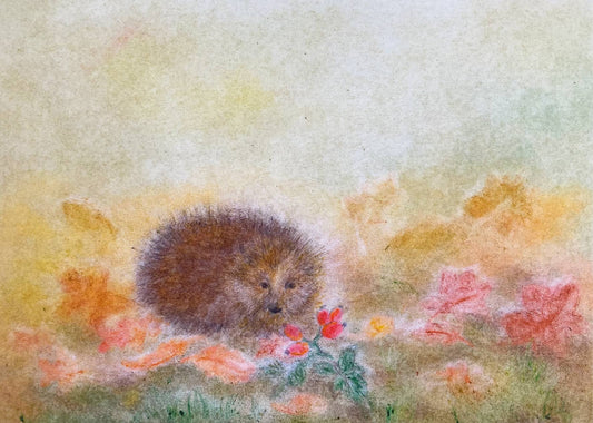 Kleiner Igel in einer bunten Herbstlandschaft mit fallenden Blättern, gestaltet in der Seccorell Finger-Wischmaltechnik auf der Postkarte „Igel im Herbst“ von Andrea Reiß.