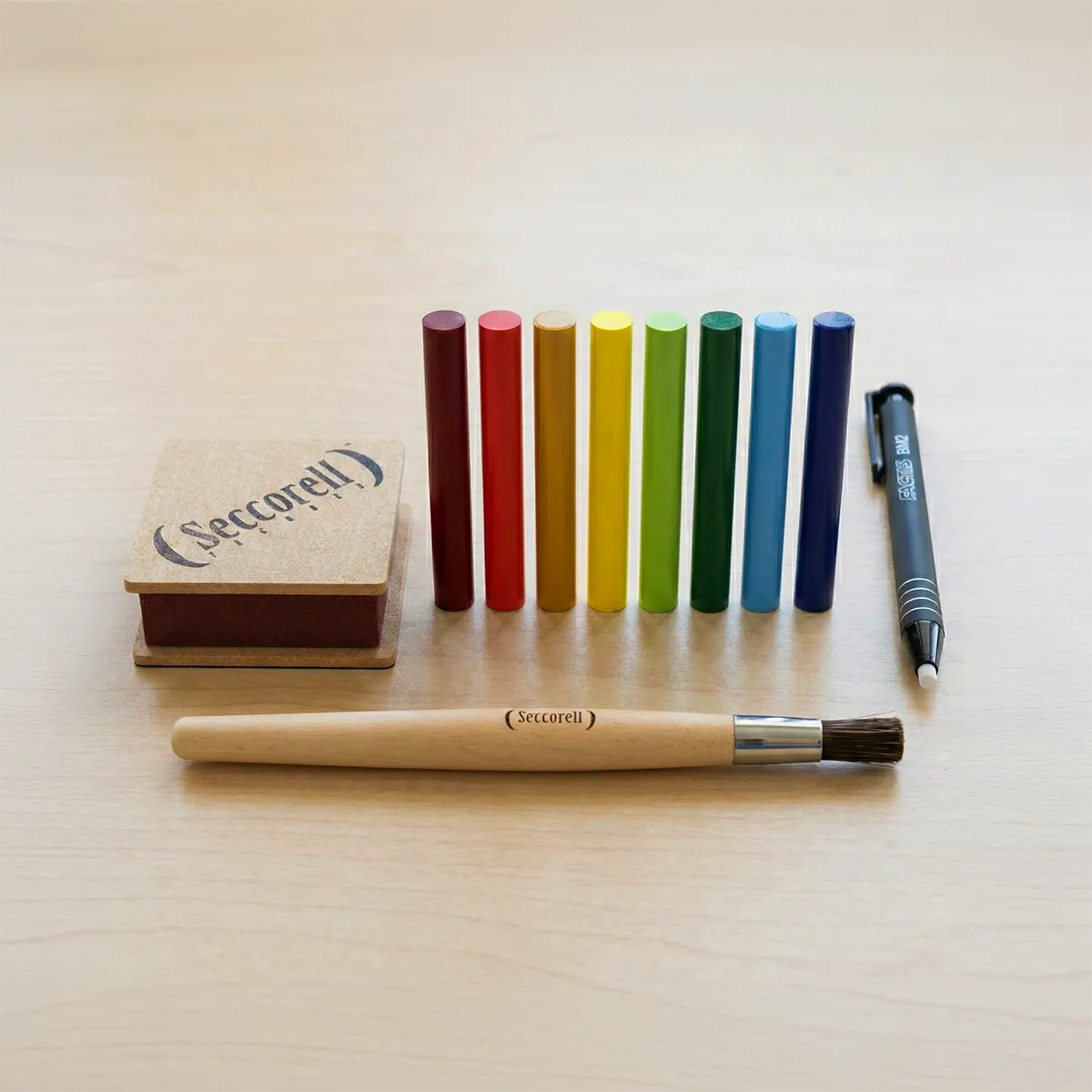 Kreisförmig angeordnete 24 Seccorell Farbstäbchen in verschiedenen Farben rund um das Seccorell-Logo in der Mitte.